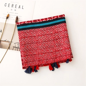 Detailed view of striped cotton scarf with colorful tassels and geometric patterns