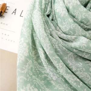 Close-up of light green linen-feel scarf with white vintage floral pattern textures