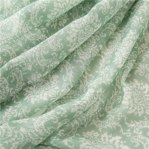 Detail of mint green scarf with white floral patterns and soft cotton-linen texture