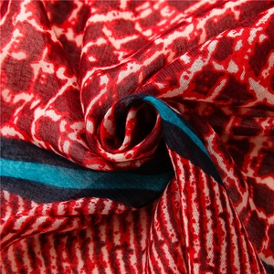 Detailed texture of retro geometric honeycomb print scarf with teal and black stripes