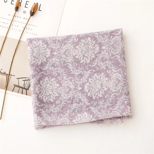 Detail of light purple floral scarf with fringe edges next to minimalist decor