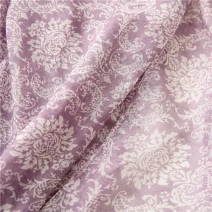Detail of purple scarf with white floral paisley patterns and soft textile texture