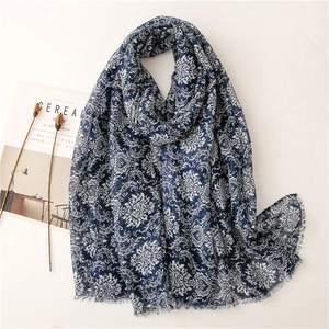 Close-up of vintage navy blue floral scarf with elegant fringe detail and soft cotton texture