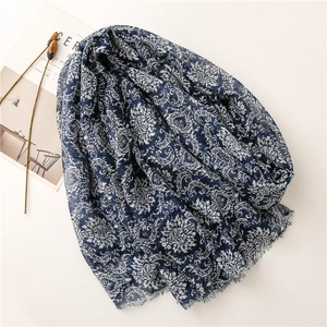 Detail of blue printed scarf with damascus patterns and natural fringe on a white surface
