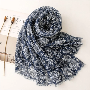 Detailed texture of blue floral print scarf with soft fringe and ethnic baroque patterns