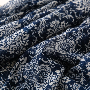 Detailed macro view of navy blue cotton-linen fabric with white paisley and floral patterns