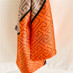 Écharpe fine en satin avec imprimé géométrique aux tons orange et marron vifs