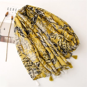 Écharpe jaune avec imprimé feuille de bananier noire et franges sur fond blanc