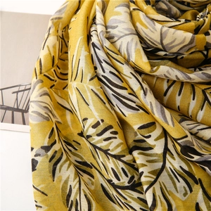 Gros plan du tissu jaune imprimé feuilles de bananier avec texture douce et tissage fin