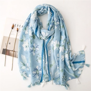 Sciarpa lunga celeste con stampe floreali bianche e nappe decorative ai bordi