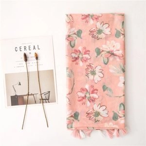 Dettaglio di sciarpa in cotone rosa con stampa floreale vintage e frange eleganti