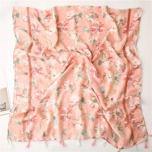 Dettaglio della sciarpa rosa a fiori con delicate nappe a frangia bianche e rosa sul bordo