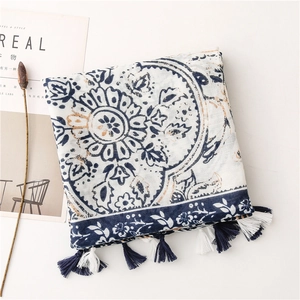 Detail of blue and white floral porcelain print scarf with bicolor fringe tassels