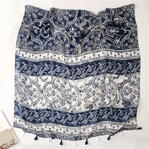 Close-up of vintage blue paisley floral scarf fabric with bohemian tassels detail