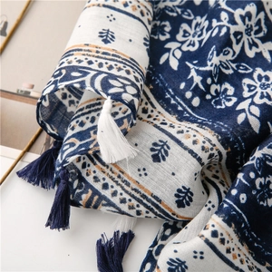 Macro shot of blue floral cotton scarf fabric with handcrafted fringe tassel details