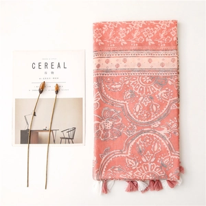 Detail of coral floral scarf with fringe trim and vintage ethnic blue porcelain print
