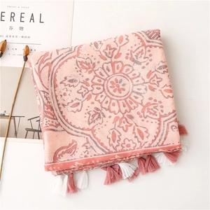 Detailed view of vintage ethnic floral scarf with decorative tassels on a magazine background