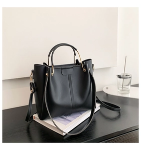 Détail d'un grand sac cabas vintage noir avec poignées dorées et texture cuir matelassé