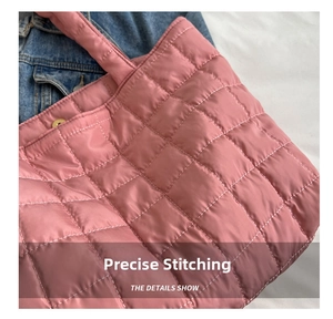 Detail of pink quilted puffer tote showing neat square stitching and metal snap closure