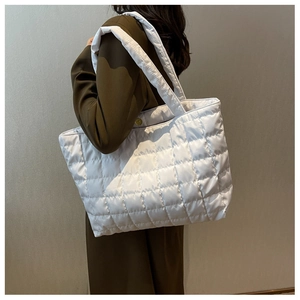 Detailed shot of white quilted tote bag with wide straps and large storage capacity
