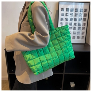 Detail view of bright green quilted tote bag in padded nylon with lattice stitching