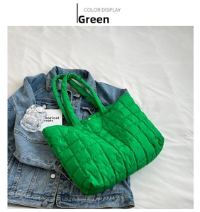 Macro detail of vibrant green quilted tote bag fabric on denim jacket and white cloth