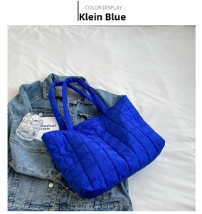 Detailed view of quilted grid puffer tote bag in Klein blue on denim fabric