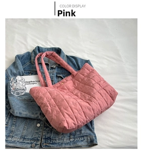 Detail of pink quilted tote bag in glossy nylon fabric on a casual denim jacket