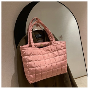 Detailed macro view of pink quilted tote bag texture and soft padded shoulder straps