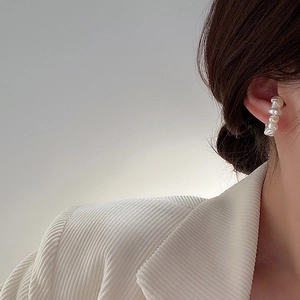 Elegant baroque pearl ear cuff for women shown on model with chic beige blazer