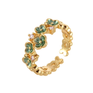 Vintage gold open ring with green enamel flowers and pink crystals on white background