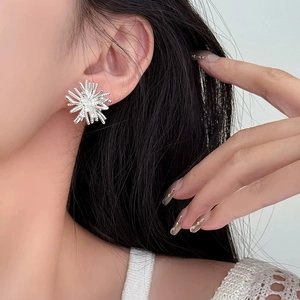 Close-up of irregular silver fireworks earrings with cubic zirconia on model