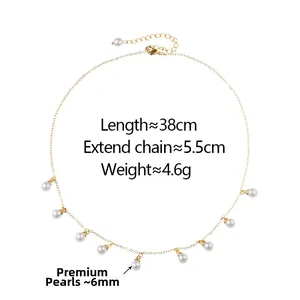 Dettaglio di un'elegante collana a catena dorata con dieci perle lucide da 6mm e chiusura a moschettone