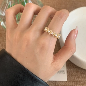 Elegant gold ring featuring alternating lustrous pearls and diamonds on a model hand