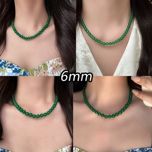 Detail view of 6mm green chalcedony beaded necklace on model in elegant retro style