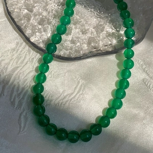 Macro detail of elegant green chalcedony beaded necklace with smooth polished texture