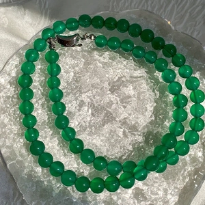 Detail of green chalcedony beaded necklace with silver clasp on ice-textured tray
