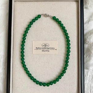 Detail of green chalcedony beaded necklace on cream tray with silver clasp closure