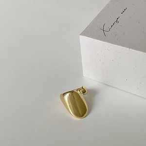 Detailed view of an elegant polished gold-plated ring with a bold curved design on white