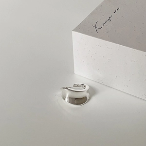 Macro shot of silver wave ring featuring a minimalist irregular mirror finish design