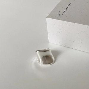 Close-up of a minimalist silver glossy wide ring with mirror finish and gift box