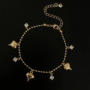 Minimalist gold heart bracelet with sparkling zircon stones on sleek black background