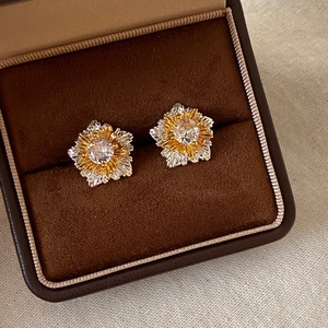 Artistic two-tone flower stud earrings with sparkling center stone in premium jewelry box