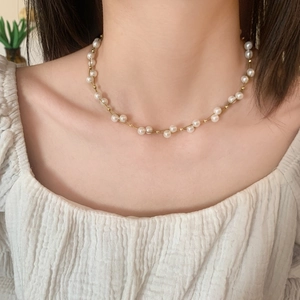 Détail d'un collier de perles élégant avec billes dorées pour un look bijoux minimaliste