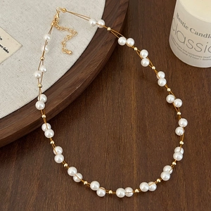 Collier de perles double épaisseur élégant avec perles dorées et fermoir sur plateau bois