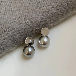 Macro shot of elegant grey pearl stud earrings with polished silver metal base