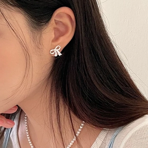 Boucles d'oreilles nœuds élégantes avec zircons étincelants portées sur mannequin