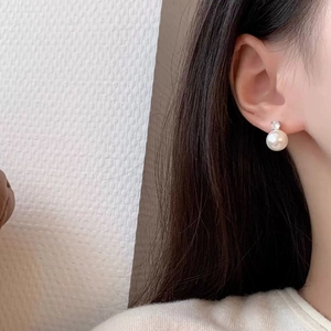 Elegant pearl stud earrings with zircon accent on model, minimalist light luxury jewelry