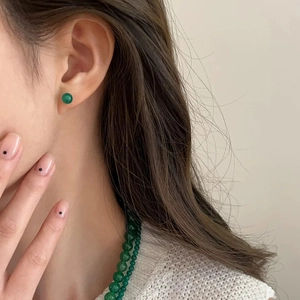 Close-up of elegant green chalcedony stud earrings paired with a matching beaded necklace