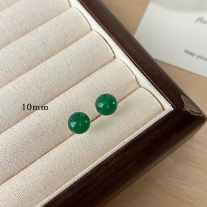 Close-up of 10mm polished green chalcedony bead earrings in a beige velvet jewelry box